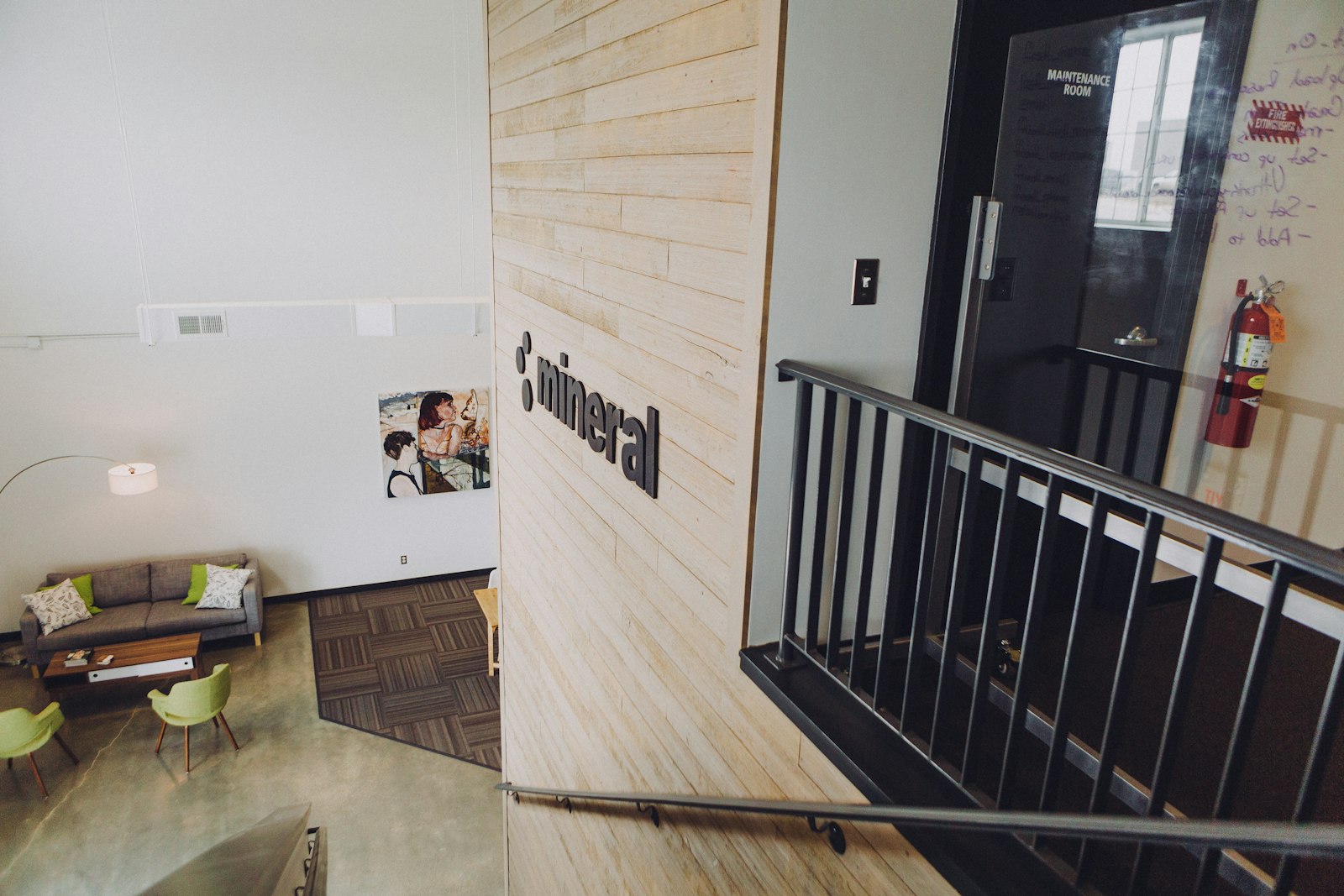 Atelier professionnel en loft avec mezzanine, tableaux et tables de travail